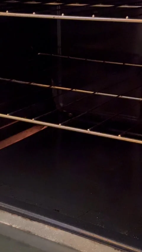 Chefs hands put a baking sheet with chicken in the oven Stock Footage 256052337