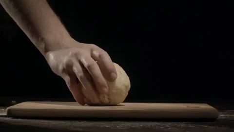 Chef's hands put homemade baking dough in form of round ball on a black Stock Footage 221495084
