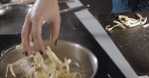 Chef's hands put paste in pot with boiling water Stock Footage 124874515