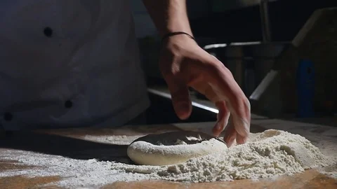 The chef's hands roll the dough into pizza. slow motion Stock Footage 77357093