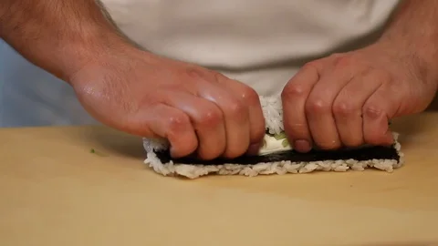 Chef's hands rolling a sushi roll. Sushi making process. Rolls the sushi roll Stock Footage 126049381