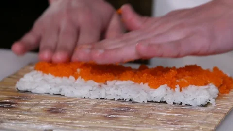 Chef's hands rolling a sushi roll. Sushi making process. Rolls the sushi roll Stock Footage 130118237