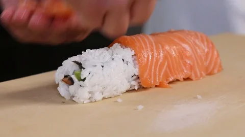 Chef's hands rolling a sushi roll. Sushi making process. Rolls the sushi roll Stock Footage 130118258