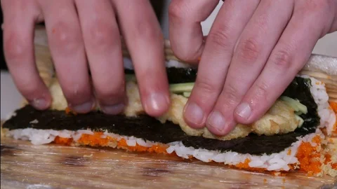 Chef's hands rolling a sushi roll. Sushi making process. Rolls the sushi roll Stock Footage 130118391