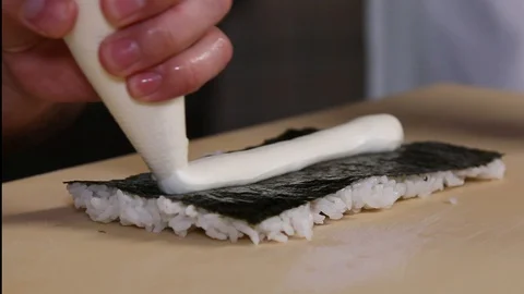 Chef's hands rolling a sushi roll. Sushi making process. Rolls the sushi roll Stock Footage 130118408