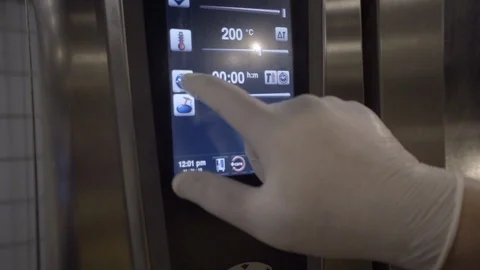 Chef's hands set the temperature in the stove Stock Footage 121830963