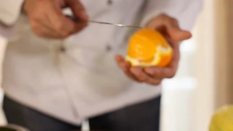 The chef's hands slice an orange with a knife.close-up Stock Footage 115479190
