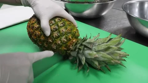 Chef's Hands Slicing Fresh Ripe Pineapple on Green Cutting Board 스톡 동영상 332811325
