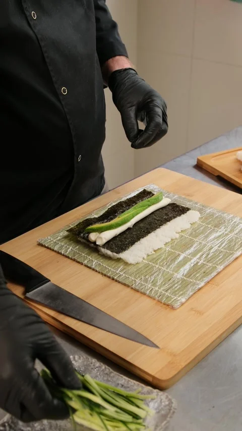 Chef's hands spread avocado and cucumber onto cream cheese. Stock Footage 262581368