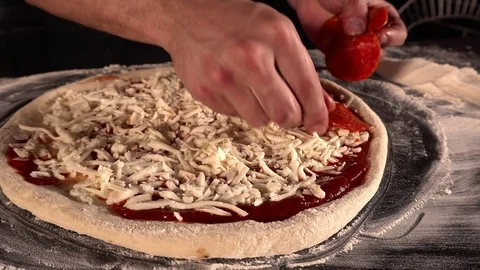 The chef's hands spread delicious salami on the pizza. Pizza with tomato sauce Stock Footage 127348626