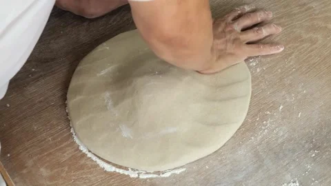 Chef’s Hands Stretching Fresh Pizza Dough on a Wooden Surface Stock Footage 333522596