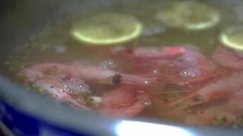 Chef's hands throw shrimps into a pan with lemon and garlic. HD Stock Footage 141447213