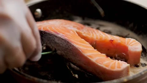 The chef's hands turn the fish steak deliciously. fry steak in a pan Stock Footage 158241906