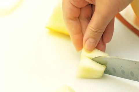 Chef's knife cutting a melon slice into small pieces for a child, showcasin.. Stock Photos