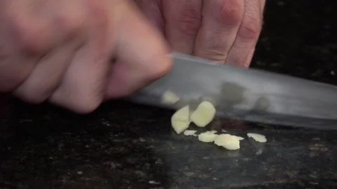 Chef’s knife mincing garlic on a dark background, 4K Stock Footage 159872700