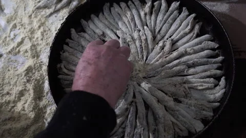 A chef's placing capelin fish on the iron pan. Stock Footage 145240222