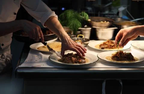 Chefs plating up in a restaurant kitchen Stock Photos
