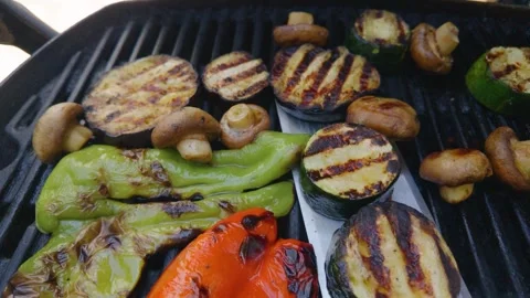 Chef's point of view removing delicious roasted vegetables like zucchini Stock Footage 342076953