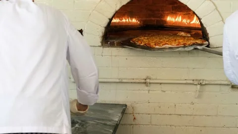 Chefs prepares the pizza, takes pizza from fired oven Stock Footage 153607098