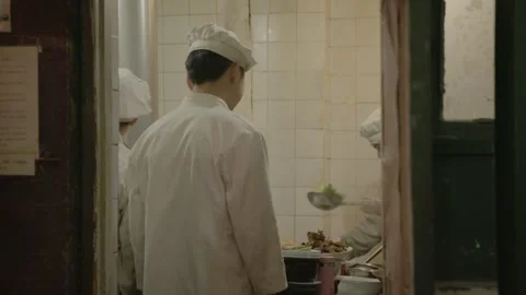 Chefs Preparing Food in Restaurant Kitchen, Beijing, China, Viewed Through Stock Footage 345771937