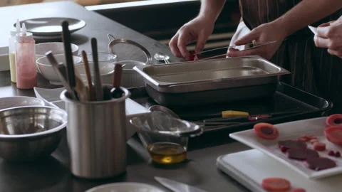 Chefs preparing slices of beets to get ready to serve in interior kitchen with s Stock Footage 199457402
