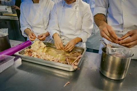 Chefs processing meat in a professional kitchen Stock Photos