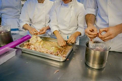 Chefs processing meat in a professional kitchen Stock Photos