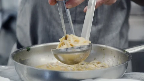 The chef's putting the pasta on the plate Stock Footage 114229995