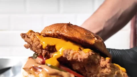 Chef's rendition of a chicken schnitzel burger with cheddar cheese Stock Footage 278348334