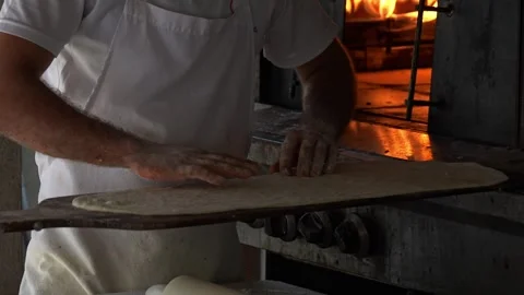 Chefs Skillfully Preparing a Delicious Pizza with Fresh Cheese in an Authentic Stock Footage 311993122