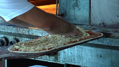 Chefs Skillfully Preparing a Delicious Pizza with Fresh Cheese in an Authentic Stock Footage 311993793