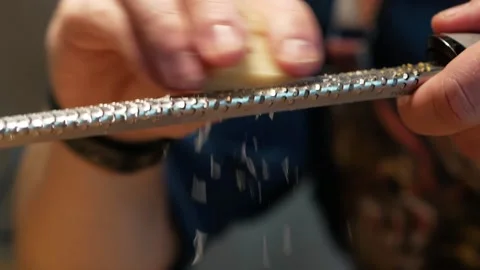 Cheft grating parmesan cheese on a small fine metal grater Stock Footage 222214966