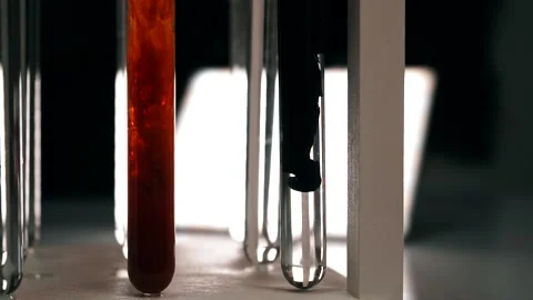 The chemical black reagent slowly dissolves in a test tube with a clear liquid Video stock 188750329