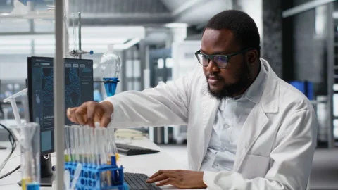 Chemical engineer in lab inspecting chemical compounds using PC software Stock Footage 320144520
