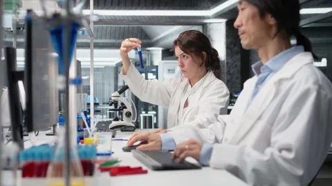 Chemical engineer using laboratory glassware with blue indicator solution Stock Footage 320144848