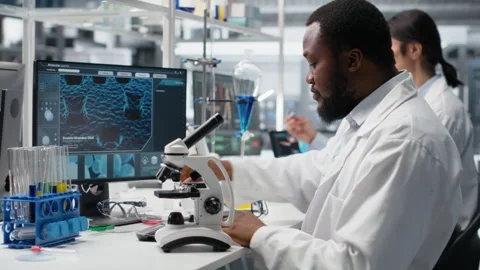 Chemical engineer using microscope to evaluate test specimens in lab Stock Footage 320147207