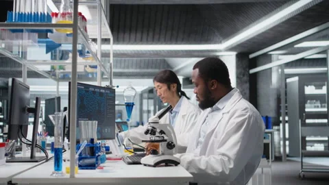 Chemical engineer using microscope to evaluate test specimens in lab Stock Footage 320743910