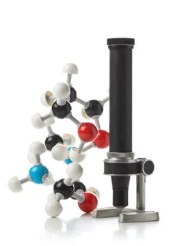Chemical molecule model with old microscope over white background Stock Photos