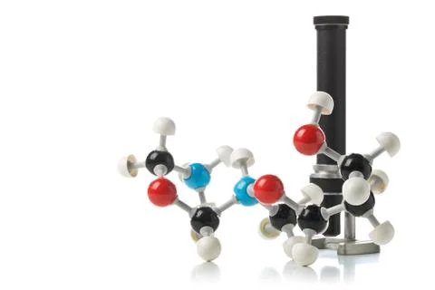 Chemical molecule model with old microscope over white background Stock Photos