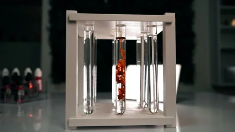 The chemical orange reagent slowly dissolves in a test tube with a clear liquid Stock Footage 188750226