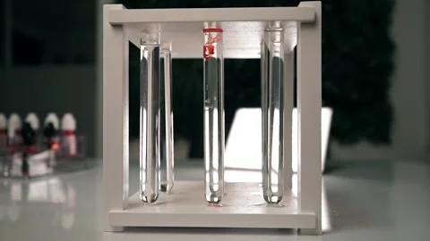 The chemical red reagent slowly dissolves in a test tube with a clear liquid Stock Footage 188749646