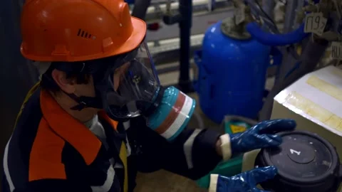 A chemical worker opens a container with a hazardous chemical element. The Stock-Footage 165864659