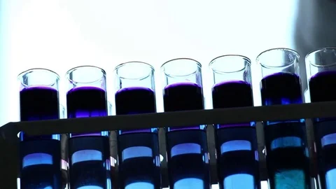 Chemist  adds reagents into  vials on dark background Stock Footage 77208764