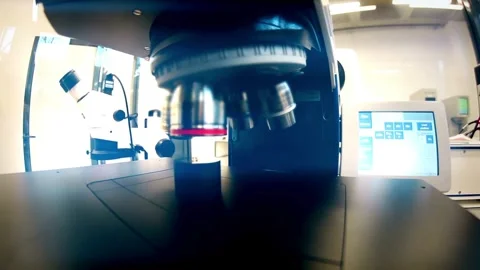 A chemist analyzes crystal formations under a sophisticated modern microscope. Stock Footage 336583228