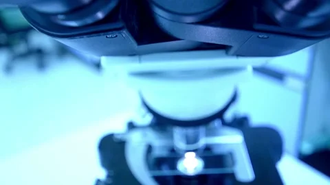 A chemist analyzes crystal formations under a sophisticated modern microscope. Stock Footage 336583247