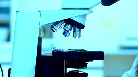 A chemist analyzes crystal formations under a sophisticated modern microscope. Stock Footage 336583257