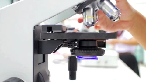 A chemist analyzes crystal formations under a sophisticated modern microscope. Stock Footage 336583287