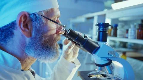 Chemist Analyzing Samples Under Microscope in Innovative Laboratory Setting Stock Photos