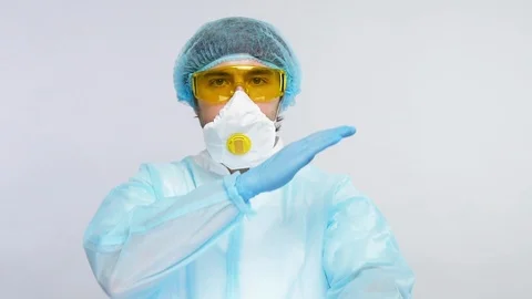 Chemist in biohazard cotume howing stop sign with arm to avooid virus spreading Stock Footage 127039412