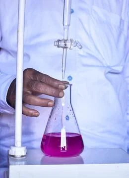 The chemist conducts acid-base titration, accurately measuring and adding s.. Stock Photos